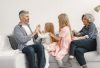 A joyful family spends quality time together, playing and bonding on a cozy sofa.