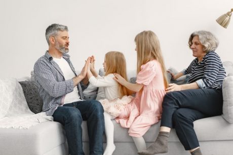 A joyful family spends quality time together, playing and bonding on a cozy sofa.