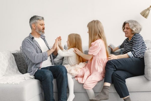 A joyful family spends quality time together, playing and bonding on a cozy sofa.